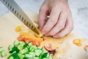chopping the cucumber and tomato for making tabbouleh