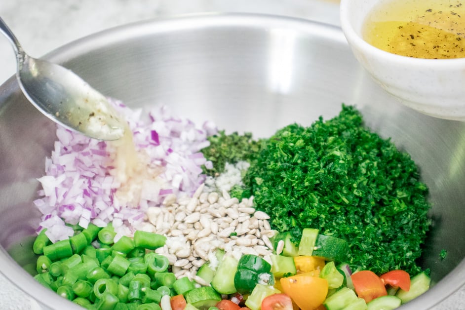 adding sauce to season the tabbouleh